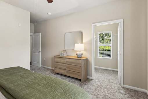 A bedroom with a bed, dresser, and mirror.