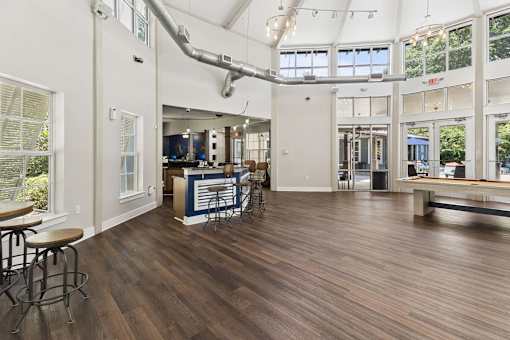 A large open space with wood flooring and a bar area.