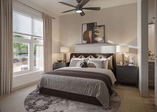 A bedroom with a large bed and a ceiling fan.
