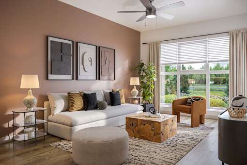 A living room with a white couch, a wooden coffee table, and a large window with blinds.