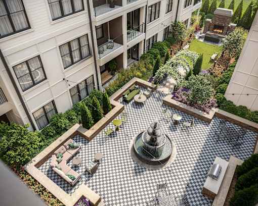 A courtyard with a fountain and seating area surrounded by buildings.