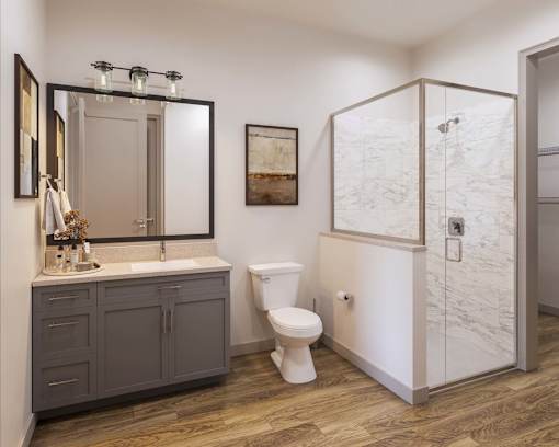 A bathroom with a white toilet and a marble wall.
