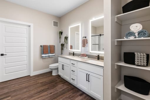 a bathroom with white cabinets and a toilet and a sink