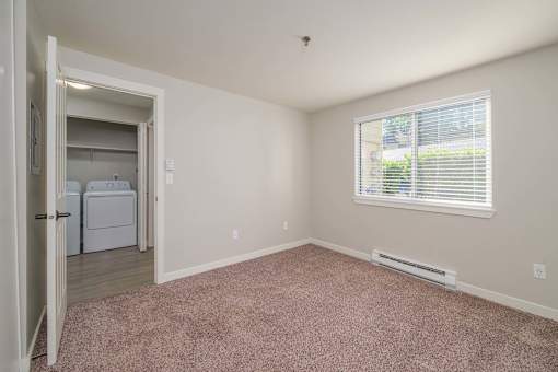 A room with a window and a door leading to another room.