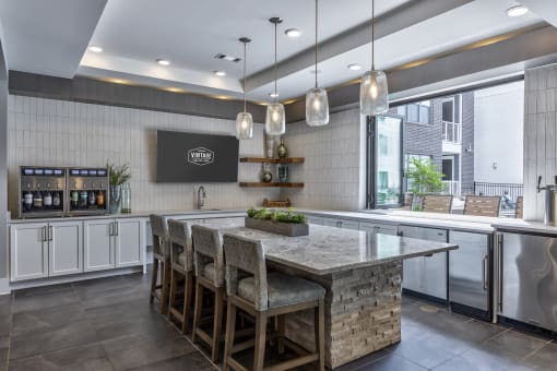 a kitchen with a large island with chairs and a counter top