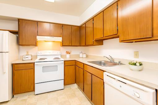 A kitchen with wooden cabinets and white appliances at Winchell Way Apartment , Kalamazoo, 49008