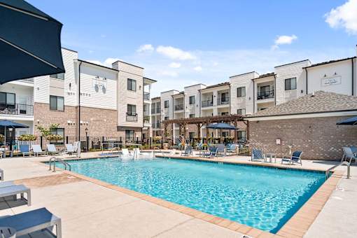 A swimming pool in front of apartment buildings.