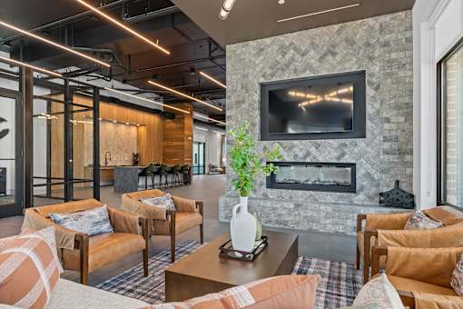 A living room with a stone fireplace and a flat screen TV mounted above it.
