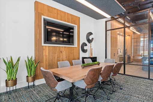 A conference room with a wooden table and chairs.
