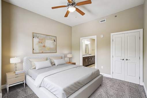 Pet-Friendly Luxury Apartments in Atlanta, GA - The Rocca - A Bedroom with Matching Bedside Tables with Lamps, a large bed, and a Ceiling Fan.