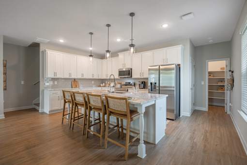A kitchen with a table and chairs in the middle of the room.