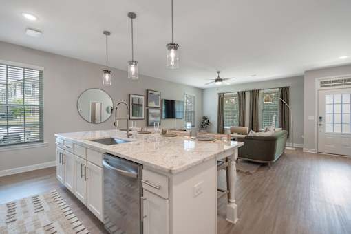 A modern kitchen with a large island and pendant lights.