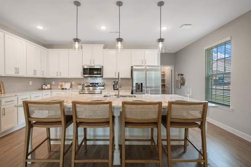 A kitchen with a table and chairs.