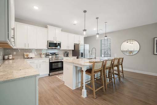 A kitchen with a table and chairs.