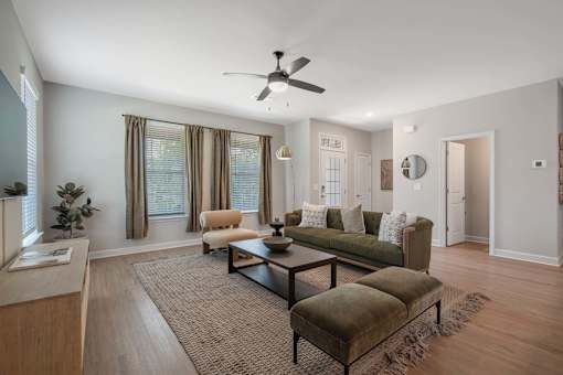 A living room with a brown rug and a green couch.