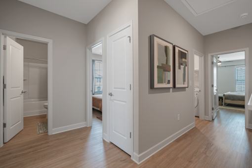 A room with a white door and a painting on the wall.