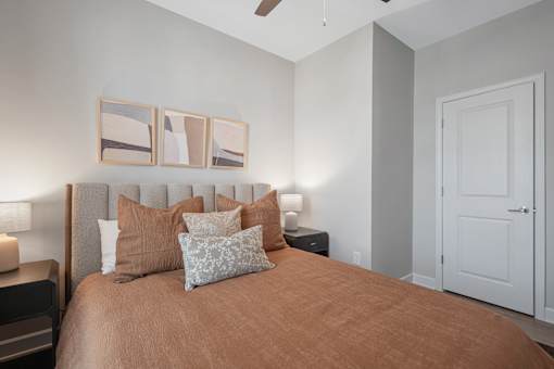 A bedroom with a bed, nightstands, and a ceiling fan.