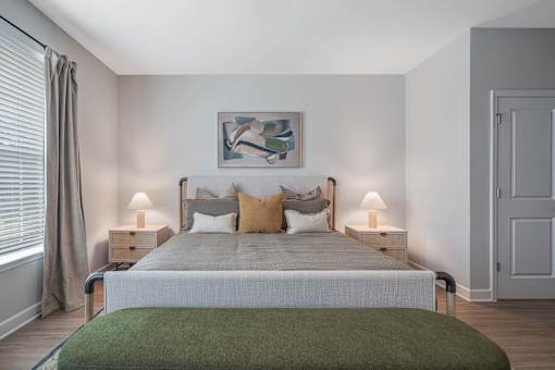 A bedroom with a large bed and a green blanket.