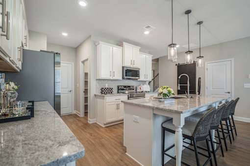A kitchen with a marble countertop and white cabinets.