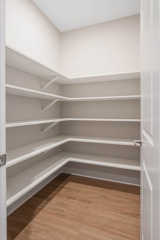 Empty white shelves in a room with a wooden floor.