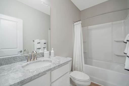 A bathroom with a sink, toilet, and bathtub.
