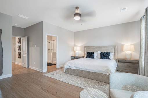 A bedroom with a large bed and a chair.