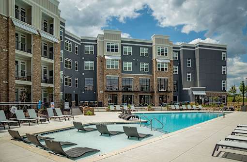 A large swimming pool in front of apartment buildings.