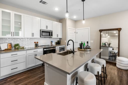 a kitchen with a large island and white cabinets