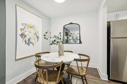 A dining room with a white table and chairs.