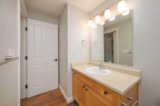 A bathroom with a sink, mirror, and lighting.