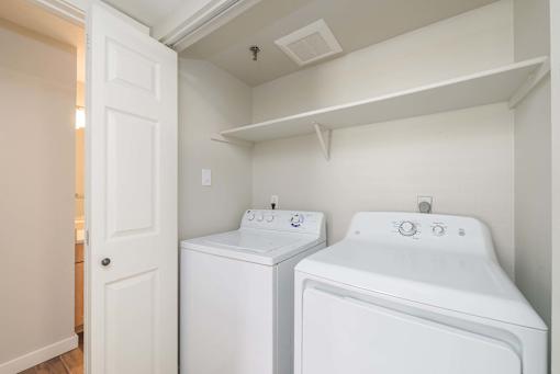 A small laundry room with a washer and dryer.
