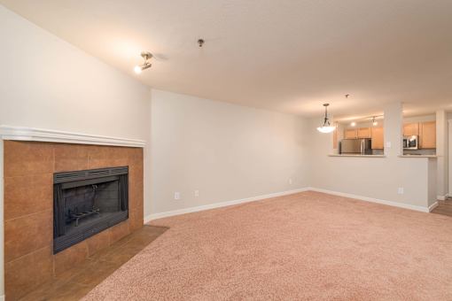 A living room with a fireplace and carpeted floor.