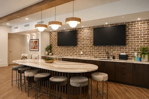 A kitchen with a bar area and a brick wall.