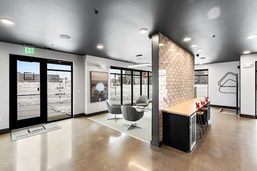 A modern office lobby with a reception desk and chairs.