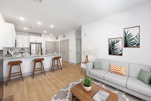 A modern living room with a grey couch and a wooden coffee table.