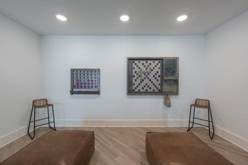 a living room with two stools and two pieces of art on the wall