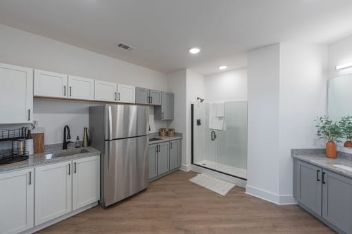 a kitchen with white cabinets and a stainless steel refrigerator
