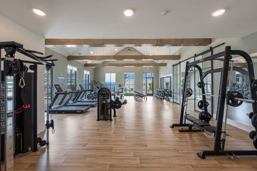 Pet-Friendly Apartments in Huntsville, AL - The Kelvin - Fitness Center with Weight Training Equipment, Treadmills, Elliptical Machines, Workout Benches, Floor-to-Ceiling Windows, and Mirror Walls.