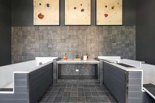 a bathroom with two tubs and paintings on the wall