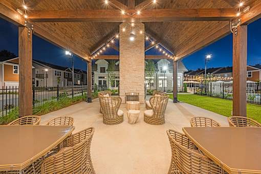 a covered patio with tables and chairs at night