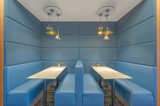 two tables and two benches in a blue booth