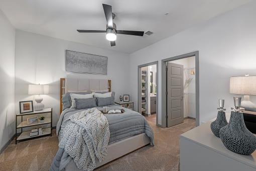 3-Bedroom Apartments in Chattanooga, TN - Populus Waterside - Carpeted Bedroom with Large Bed, Nightstands, Lamps, Private Bathroom, Spacious Closet, and Ceiling Fan.