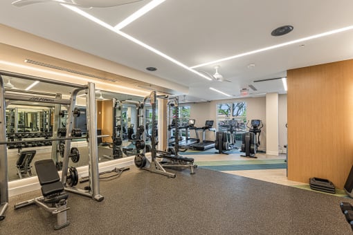 a gym with cardio machines and weights on the floor