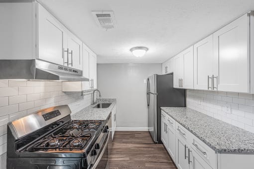 a kitchen with white cabinets and a stove and refrigerator