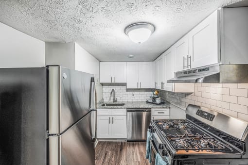a kitchen with stainless steel appliances and white cabinets