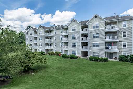 A large apartment complex with a green lawn in front.