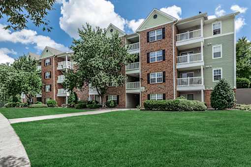 A large grassy area in front of apartment buildings.