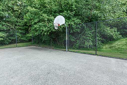 A basketball hoop stands in the middle of an outdoor court.