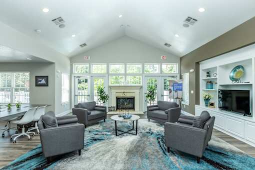 A living room with a fireplace and grey couches.