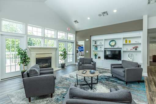 A living room with a fireplace and grey couches.